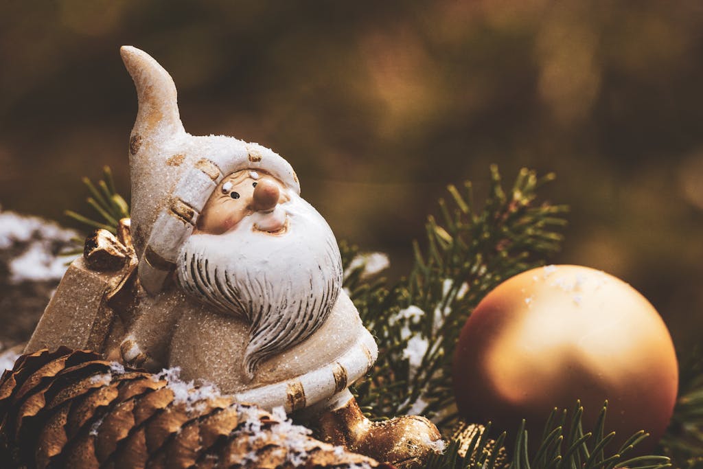 A charming Christmas gnome decoration with a golden ornament among pine needles.